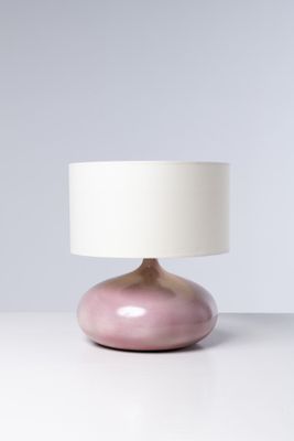 une lampe de table rose surmontée d'un abat-jour blanc