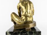 bronze statue of a man sitting on a marble base