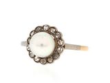 a close up of a pearl and diamond ring on a white background