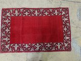 a red rug on the floor next to a pair of shoes