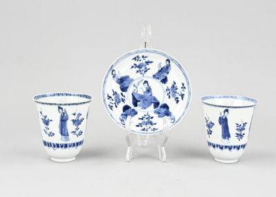three blue and white porcelain cups and a saucer on a stand
