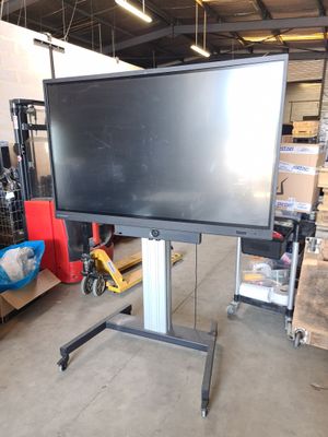 a large flat screen tv sitting on a stand in a warehouse