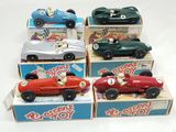 several toy cars are lined up in a row on a white surface