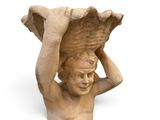 une statue représentant un garçon tenant un bol sur la tête