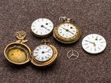 quatre montres de poche différentes posées sur une table