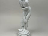 statue d'une femme tenant une fleur dans sa main droite