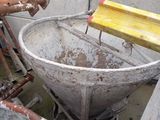 a large metal bowl sitting next to a rusty pipe