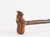a small wooden pipe with a man in a hat on it