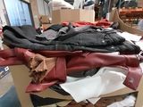 a pile of clothes sitting on top of a cardboard box