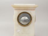 a white marble clock with a mirror on top of it