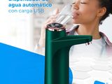 the girl is drinking from the green water dispenser