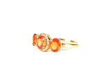 a close up of a yellow gold ring with three orange stones