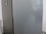 un petit réfrigérateur posé sur une étagère dans une pièce