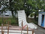 Plusieurs morceaux de bois sont empilés les uns sur les autres devant un bâtiment.