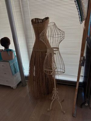 un mannequin vêtu d'une robe, posé sur un pied dans une pièce