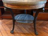 une image représentant une table ronde avec un plateau en bois posée sur un parquet