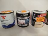 three cans of paint are lined up on a white surface