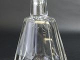 a clear glass bottle with a stopper on a black surface
