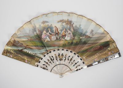 an old fan with a painting on it sitting on top of a table