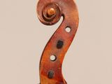 a close up of the back of a violin with a fiddle in the foreground