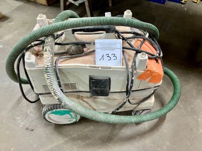 une machine posée à même le sol, équipée d'un tuyau