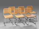 four wooden chairs with metal legs and a wicker seat