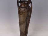 a vase that is sitting on a stand on a white surface