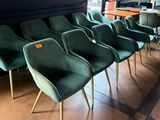 Plusieurs chaises vertes sont alignées en rang dans un restaurant