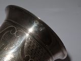 a silver vase that is sitting on a table