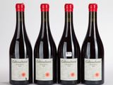 trois bouteilles de vin rouge sont alignées sur une surface blanche