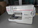 a white sewing machine sitting on a table in a room