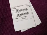 three tags attached to a purple sweater with a barcode on it
