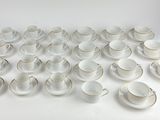 a lot of cups and saucers sitting on a table