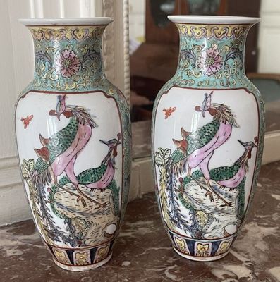 two vases sitting on a table with a mirror in the background