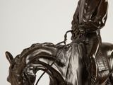 statue of a man riding a horse with a hat on his head