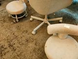 a white chair and two stools in a room
