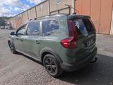 a green car that is parked on the side of the road