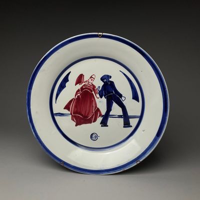 assiette bleue et blanche sur laquelle est représenté un homme et une femme