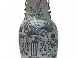 un vase bleu et blanc posé sur une surface blanche