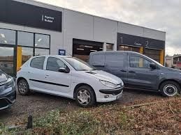 deux voitures garées devant un concessionnaire automobile, sur un parking