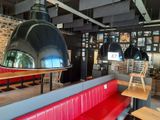 des tables et des bancs dans un restaurant où une grande lampe est suspendue au plafond