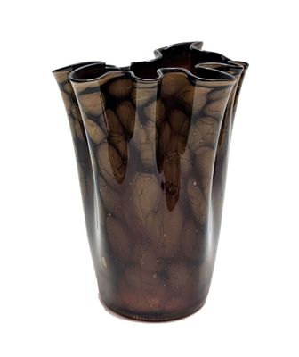 un vase brun posé sur une surface blanche