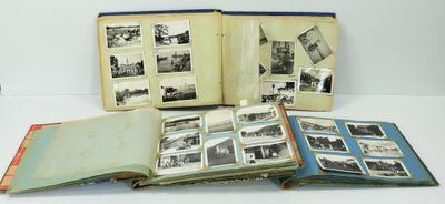 un livre ouvert posé sur une table blanche, à côté d'une pile de photos
