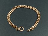gros plan d'un bracelet en chaîne en or sur une surface noire