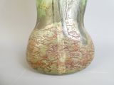 a glass vase with a gold and green design on it