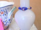 a white vase and a blue vase sitting on a table