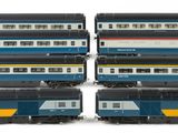 four trains sitting next to each other on a white surface