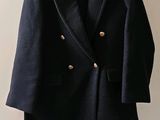 un manteau accroché au mur à côté de vêtements sur des cintres