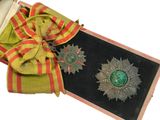 une petite boîte ornée d'un ruban et d'une médaille