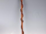 an old wooden walking stick with a twisted handle on a white background